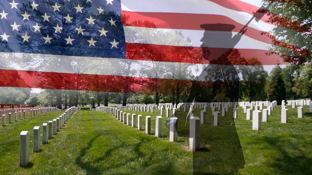 Grave stones in a row with a soldier silhouette and a US National flag